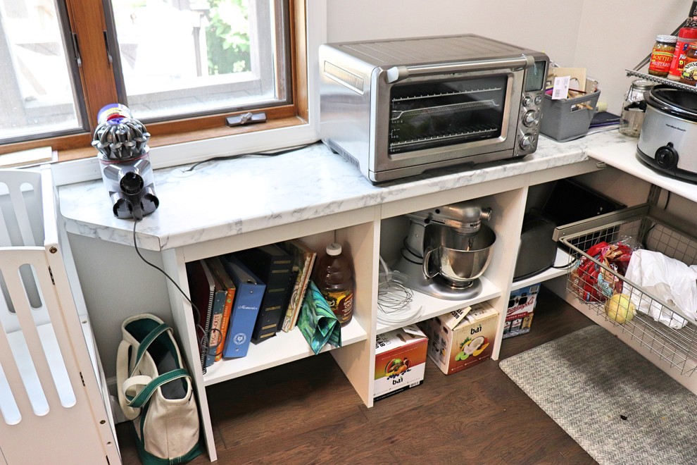 Transitional l-shaped medium tone wood floor and brown floor kitchen pantry photo in Cedar Rapids with an undermount sink, recessed-panel cabinets, white cabinets, quartzite countertops, gray backsplash, porcelain backsplash, stainless steel appliances, an island and white countertops