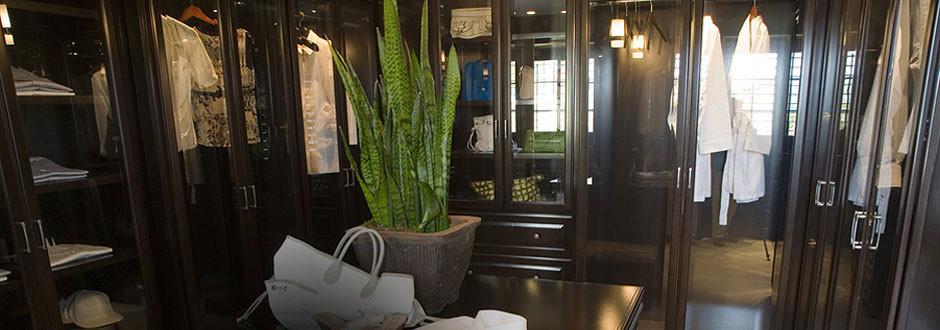 Example of a large transitional gender-neutral dark wood floor walk-in closet design in Toronto with raised-panel cabinets and dark wood cabinets