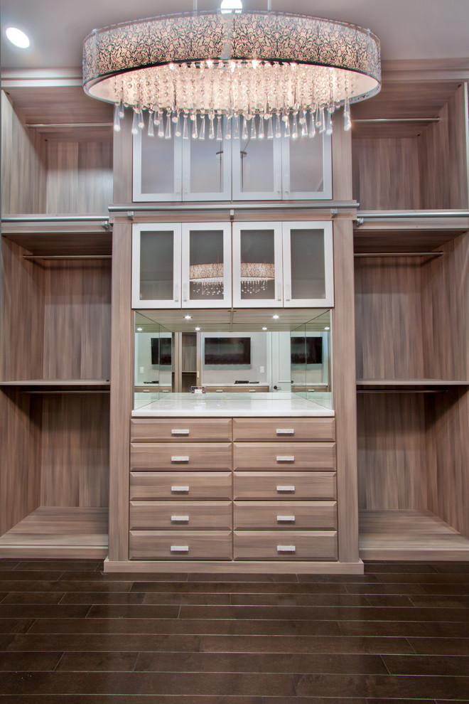 This is an example of an expansive transitional women's walk-in wardrobe in Miami with raised-panel cabinets, dark wood cabinets and dark hardwood floors.
