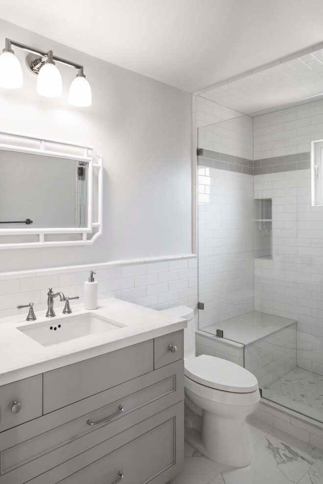 Shower bench - mid-sized transitional 3/4 white tile and subway tile marble floor, white floor and single-sink shower bench idea in Los Angeles with gray cabinets, a one-piece toilet, white walls, an undermount sink, quartz countertops, a hinged shower door, white countertops and a freestanding vanity