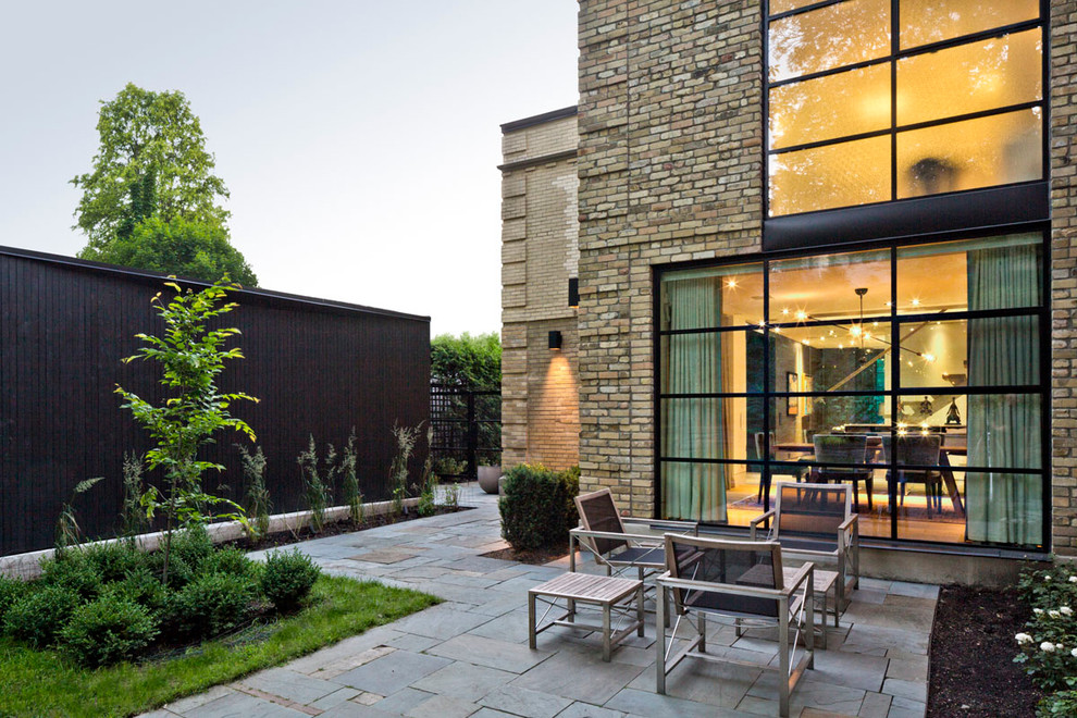 Large contemporary two-storey brick beige exterior in Toronto with a flat roof.
