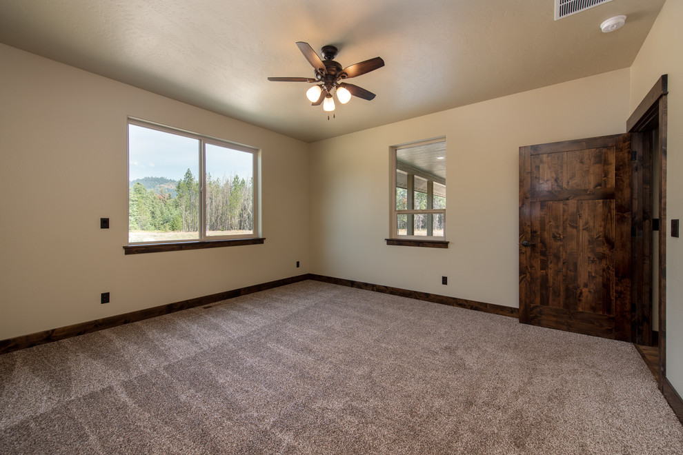 This is an example of a mid-sized country master bedroom in Other with beige walls, carpet, no fireplace and grey floor.