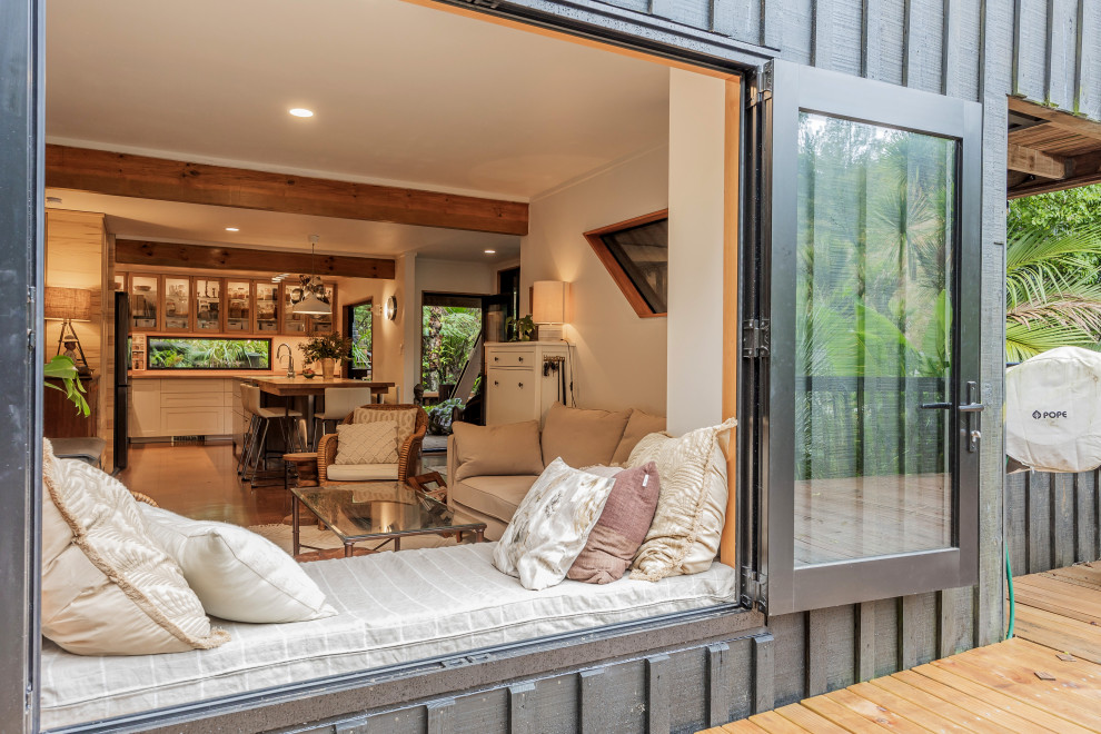 Immagine di un piccolo soggiorno bohémian aperto con pareti bianche, pavimento in sughero, stufa a legna e pavimento marrone