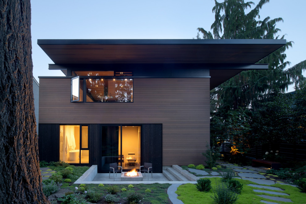 Inspiration for a contemporary three-storey house exterior in Seattle with wood siding, a flat roof, a tile roof and a black roof.