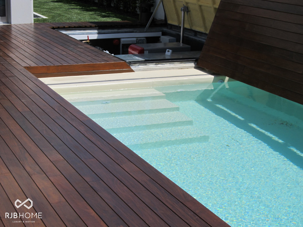 Foto de piscina moderna grande a medida con entablado