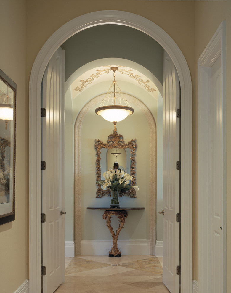 Design ideas for a large mediterranean hallway in Miami with beige walls and travertine floors.