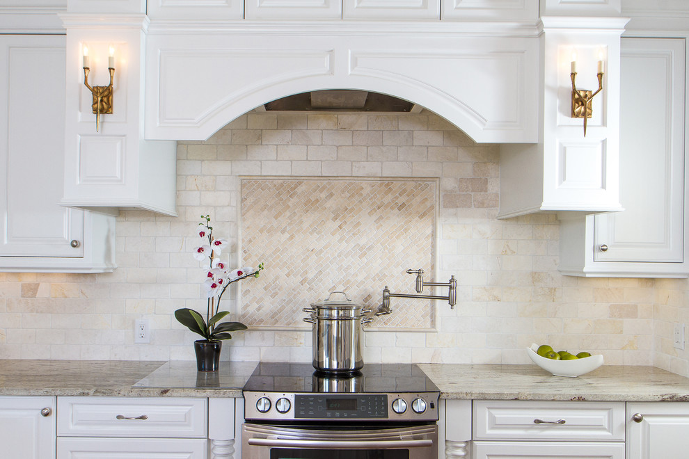 Large transitional l-shaped medium tone wood floor eat-in kitchen photo in Austin with a farmhouse sink, raised-panel cabinets, white cabinets, granite countertops, beige backsplash, ceramic backsplash, stainless steel appliances and an island