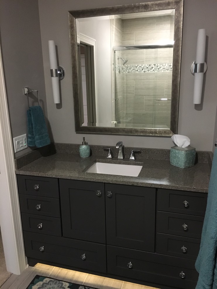 Alcove bathtub - small transitional kids' gray tile and porcelain tile porcelain tile alcove bathtub idea in Milwaukee with shaker cabinets, gray cabinets, a two-piece toilet, gray walls, an undermount sink and solid surface countertops