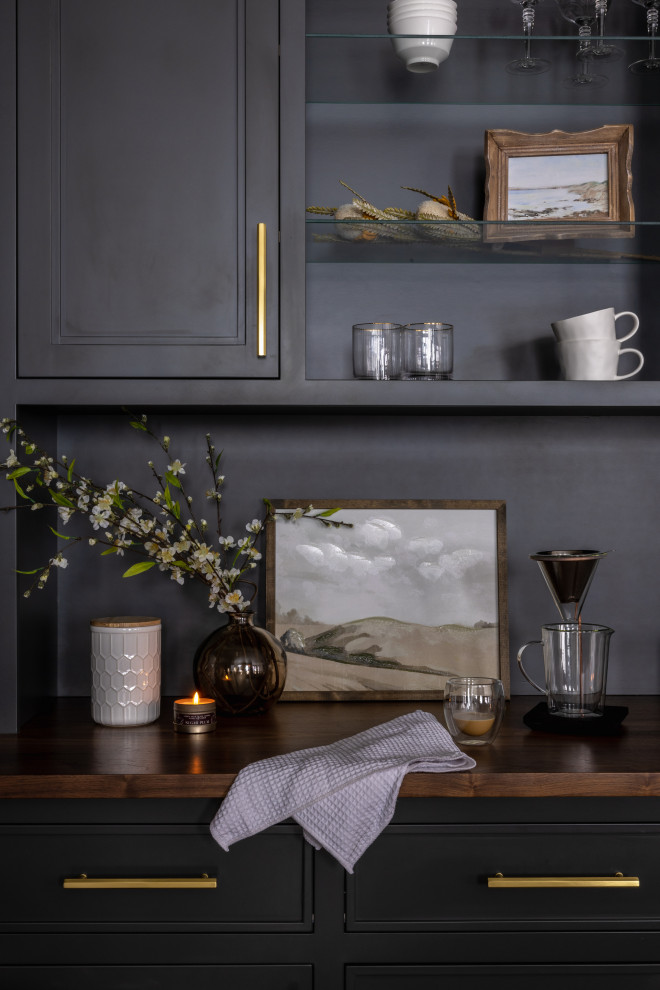 Mid-sized transitional l-shaped light wood floor and brown floor eat-in kitchen photo with a farmhouse sink, shaker cabinets, blue cabinets, quartz countertops, white backsplash, quartz backsplash, black appliances, an island and white countertops
