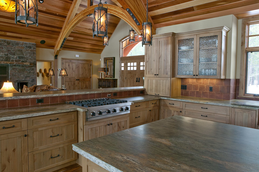 Example of a large mountain style u-shaped dark wood floor eat-in kitchen design with a drop-in sink, light wood cabinets, granite countertops, red backsplash, cement tile backsplash, stainless steel appliances, an island and beaded inset cabinets