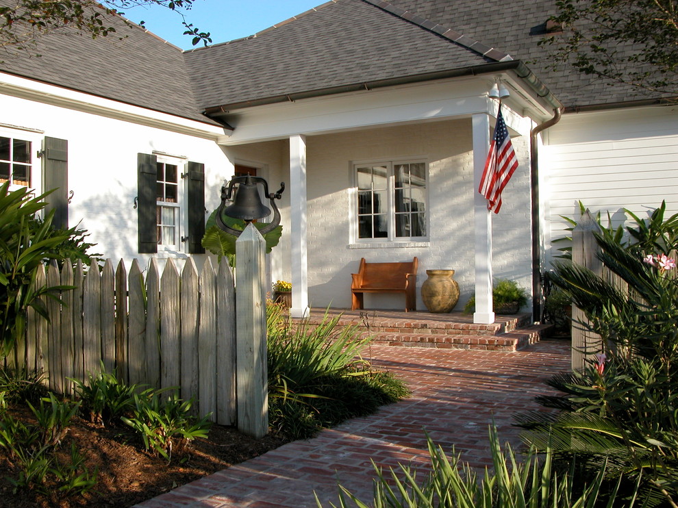Large traditional two-storey brick white exterior in New Orleans with a gable roof.