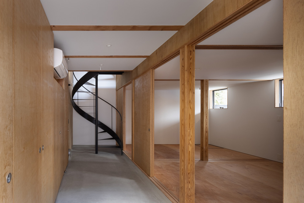 Mid-sized asian entry hall in Tokyo with brown walls, concrete floors, a sliding front door, a gray front door, grey floor, exposed beam and planked wall panelling.