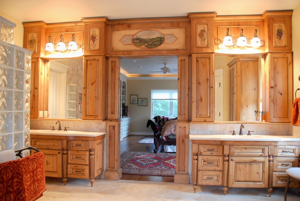 Large mountain style master travertine floor and beige floor bathroom photo with raised-panel cabinets, light wood cabinets, beige walls, an undermount sink and quartz countertops