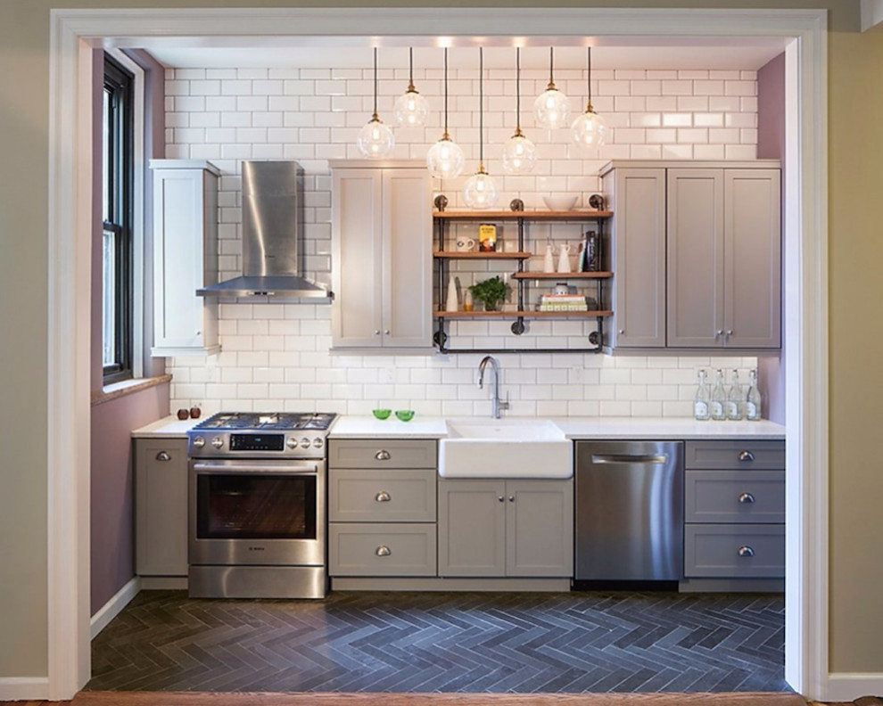 Example of a small transitional galley slate floor and gray floor eat-in kitchen design with a farmhouse sink, shaker cabinets, gray cabinets, quartz countertops, white backsplash, subway tile backsplash, stainless steel appliances, no island and white countertops