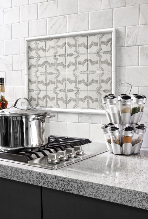 Kitchen - mid-sized transitional kitchen idea in Orange County with flat-panel cabinets, black cabinets, granite countertops, gray backsplash, stone tile backsplash and stainless steel appliances