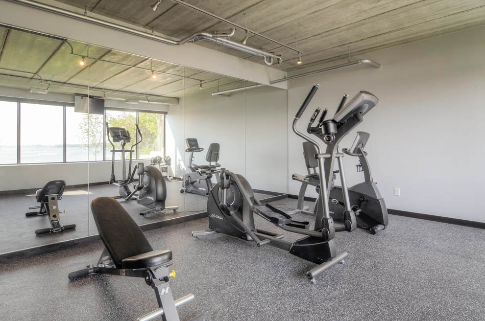 Modern multipurpose gym in Minneapolis with white walls and grey floor.