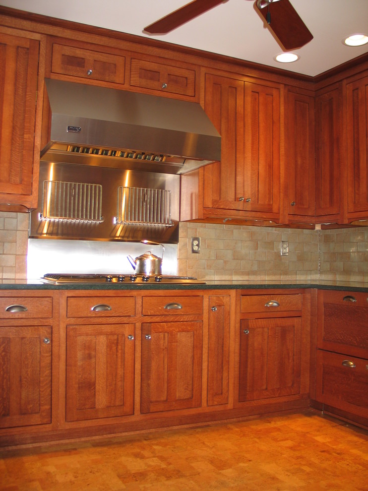 Inspiration for a mid-sized arts and crafts u-shaped separate kitchen in Chicago with an undermount sink, shaker cabinets, medium wood cabinets, stainless steel appliances and cork floors.