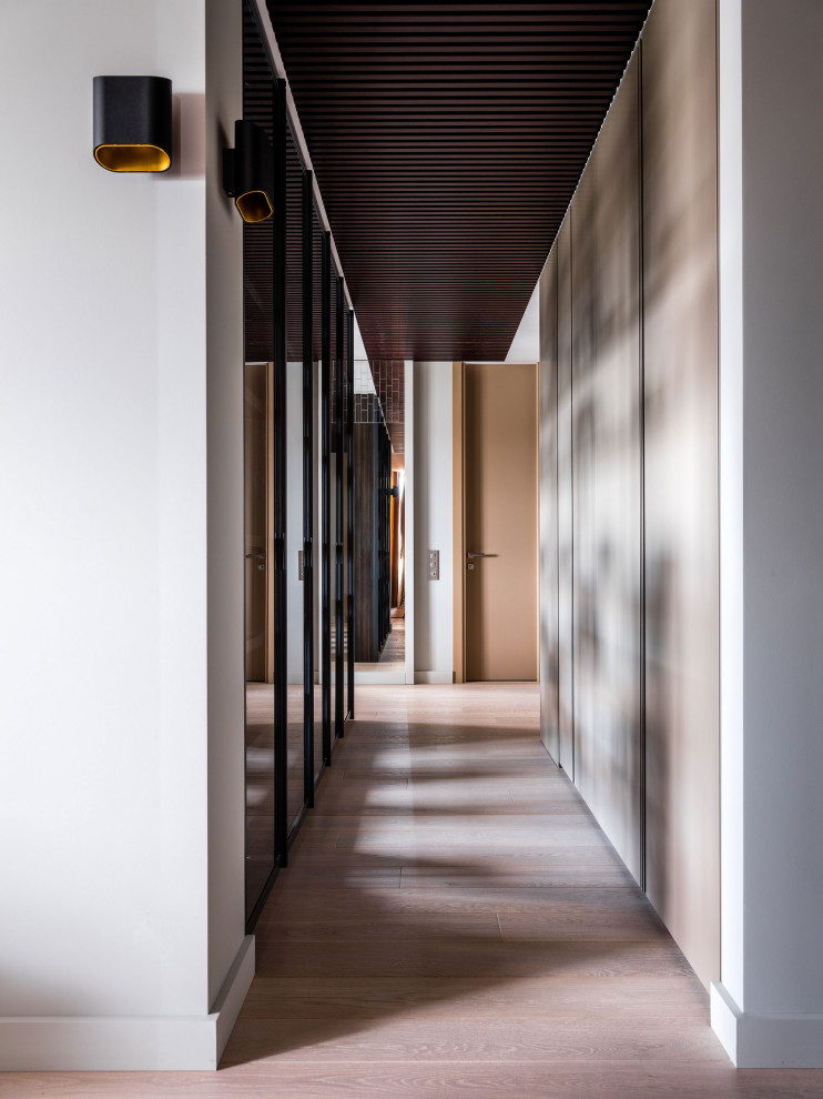 Imagen de recibidores y pasillos actuales de tamaño medio con paredes beige, suelo de madera en tonos medios, suelo beige, vigas vistas y papel pintado