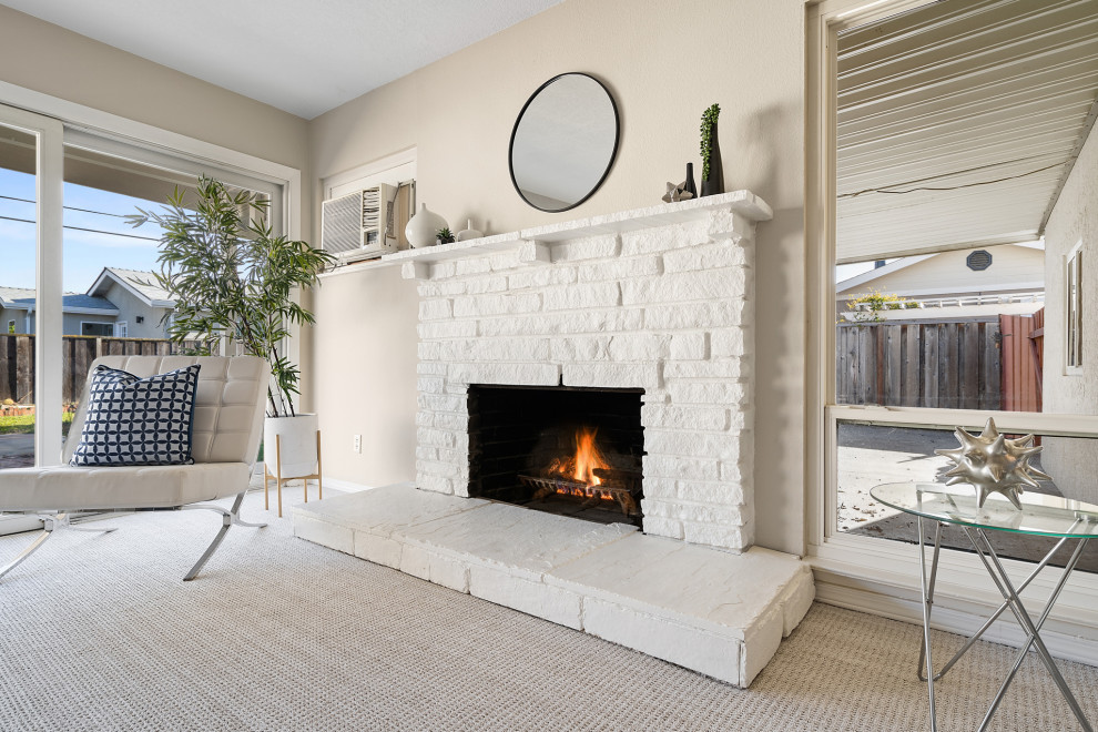 Design ideas for a contemporary open plan living room in San Francisco with beige walls, carpet, a standard fireplace, a brick fireplace surround and grey floors.