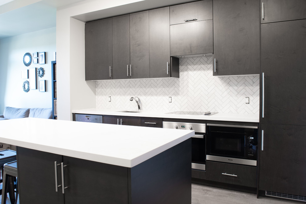 Inspiration for a mid-sized modern galley open plan kitchen in Toronto with an undermount sink, flat-panel cabinets, brown cabinets, quartz benchtops, white splashback, ceramic splashback, stainless steel appliances, laminate floors, with island, brown floor and white benchtop.