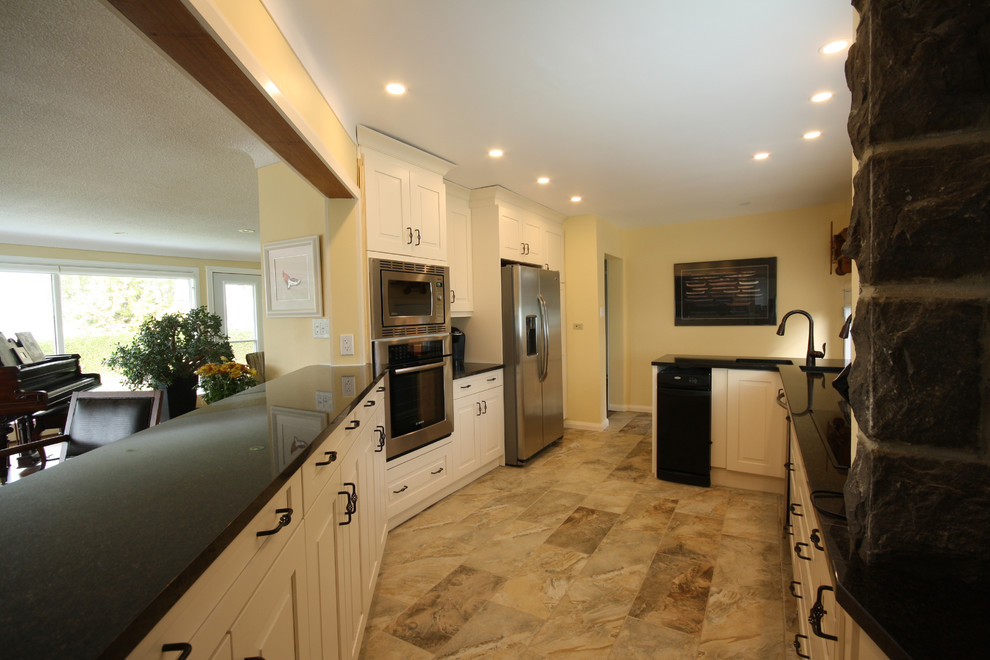 Small transitional porcelain tile enclosed kitchen photo in Ottawa with an undermount sink, raised-panel cabinets, white cabinets, granite countertops and stainless steel appliances