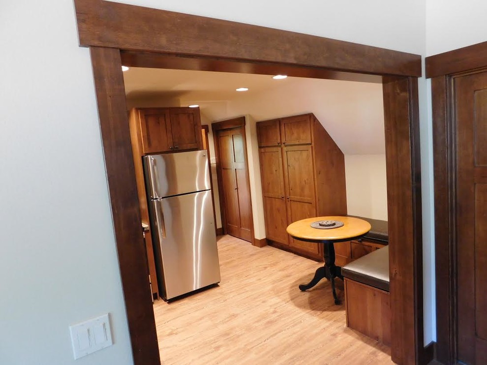 This is an example of a small arts and crafts l-shaped separate kitchen in Seattle with a drop-in sink, shaker cabinets, medium wood cabinets, laminate benchtops, stainless steel appliances, light hardwood floors, no island and beige floor.