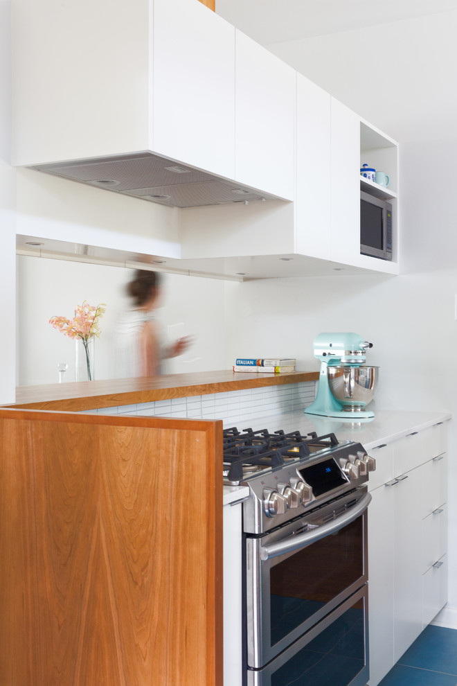 Design ideas for a small midcentury galley kitchen in Austin with a farmhouse sink, flat-panel cabinets, white cabinets, quartz benchtops, white splashback, ceramic splashback, porcelain floors and blue floor.