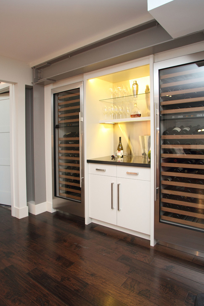 This is an example of a mid-sized contemporary wine cellar in Calgary with dark hardwood floors and storage racks.
