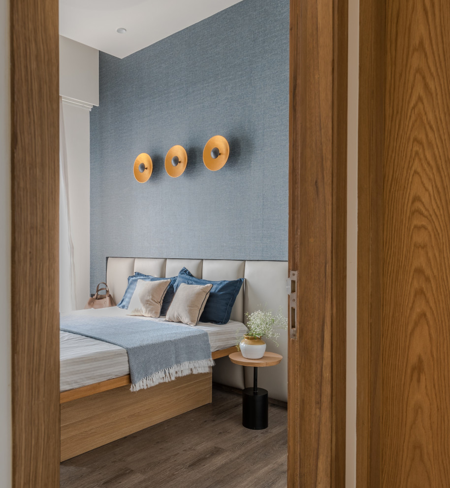 Diseño de dormitorio contemporáneo con paredes azules, suelo de madera en tonos medios, suelo marrón y papel pintado