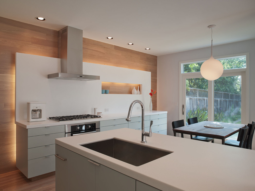 Design ideas for a modern eat-in kitchen in Austin with a single-bowl sink, flat-panel cabinets, quartz benchtops, white splashback, stone slab splashback and green cabinets.