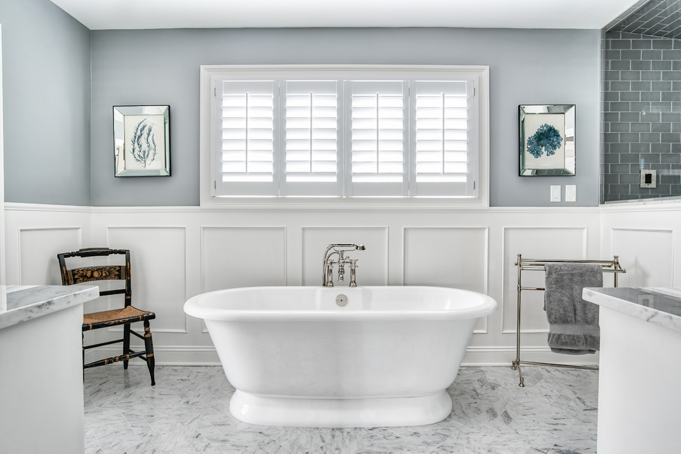 Photo of a large traditional master bathroom in New York with a freestanding tub, grey walls, marble floors, gray tile, subway tile and grey floor.