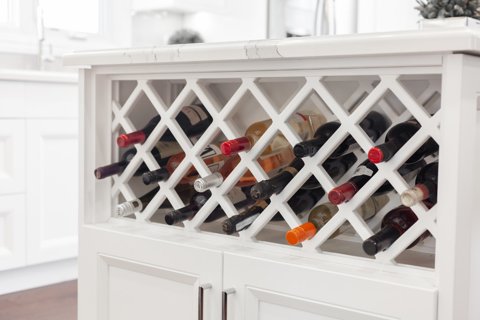 Inspiration for a large transitional l-shaped medium tone wood floor and brown floor enclosed kitchen remodel with an undermount sink, recessed-panel cabinets, white cabinets, quartz countertops, gray backsplash, ceramic backsplash, stainless steel appliances, an island and white countertops