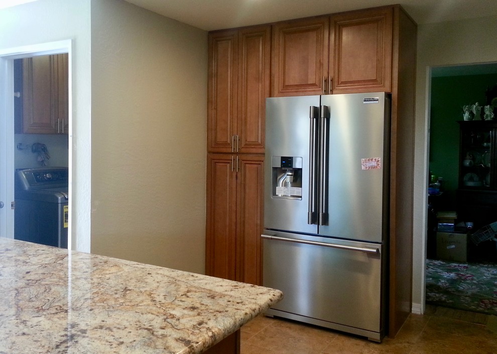Transitional ceramic tile kitchen photo in Phoenix with an island, raised-panel cabinets, medium tone wood cabinets, granite countertops and stainless steel appliances