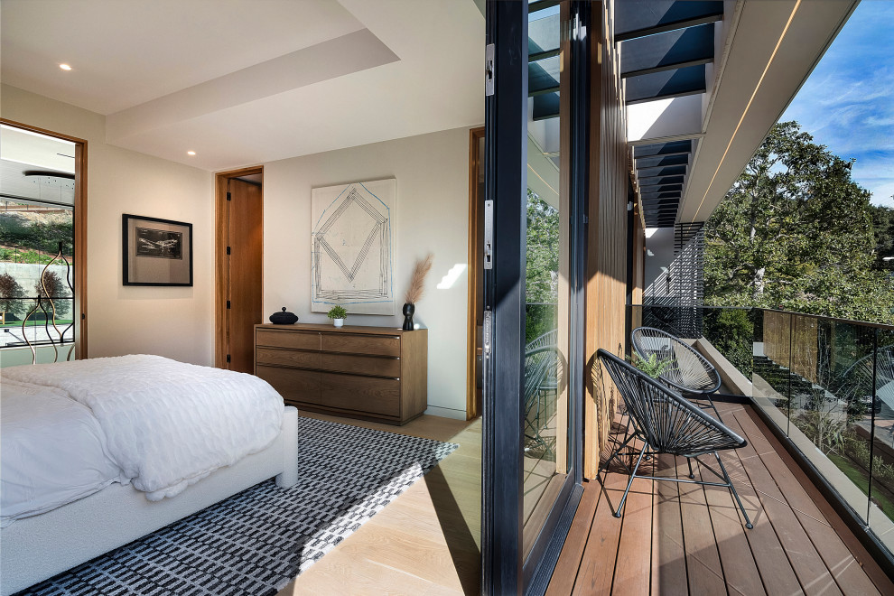 Example of a small trendy glass railing balcony design in Los Angeles with a roof extension