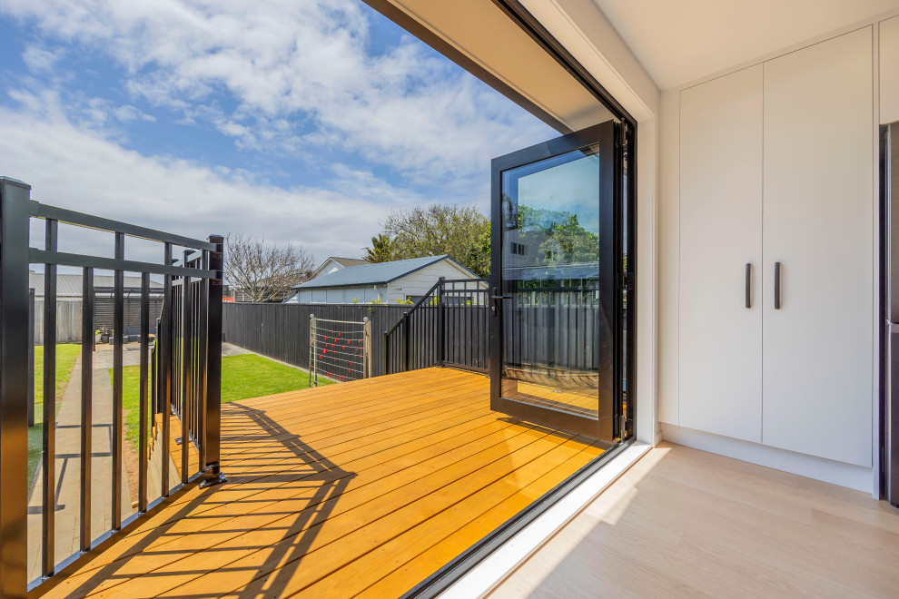 This is an example of a small modern back ground level metal railing terrace in Auckland with no cover.