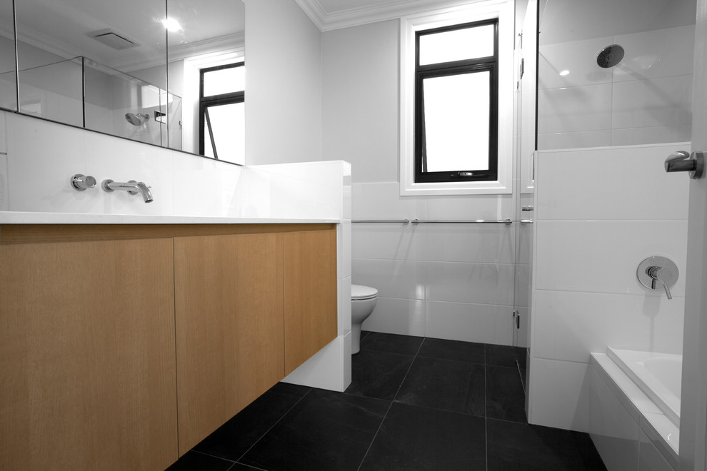 Inspiration for a large contemporary master bathroom in Brisbane with flat-panel cabinets, a drop-in tub, a corner shower, a one-piece toilet, white tile, ceramic tile, beige walls, ceramic floors, a drop-in sink, brown floor, a hinged shower door and white benchtops.