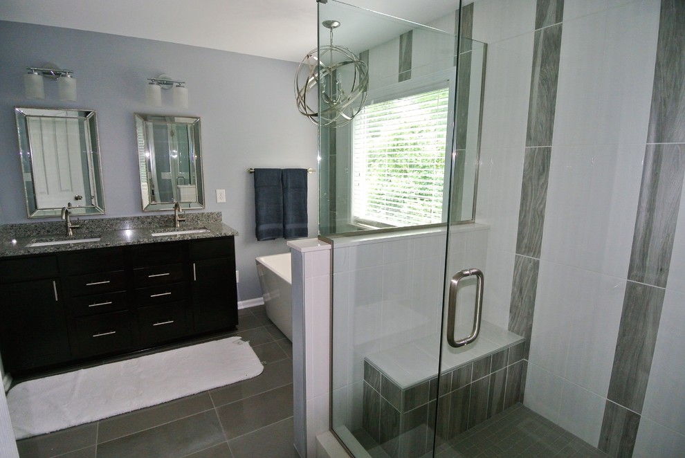 Small transitional master bathroom in Indianapolis with raised-panel cabinets, dark wood cabinets, a freestanding tub, a double shower, gray tile, ceramic tile, green walls, ceramic floors, an undermount sink and limestone benchtops.