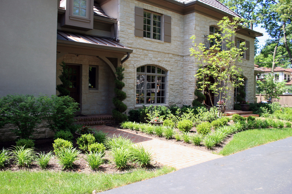 Inspiration for a traditional front yard garden in Kansas City with brick pavers.