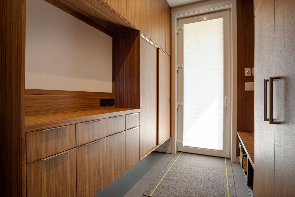 Großes Modernes Ankleidezimmer mit Einbauschrank, flächenbündigen Schrankfronten, hellbraunen Holzschränken und Betonboden in Vancouver