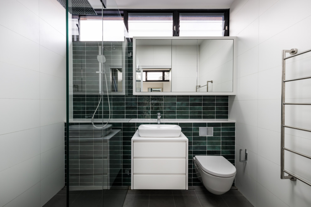 Photo of a small contemporary master bathroom in Sydney with white cabinets, an open shower, a wall-mount toilet, green tile, ceramic tile, white walls, ceramic floors, a vessel sink, engineered quartz benchtops, grey floor, an open shower, white benchtops, a single vanity, a floating vanity and flat-panel cabinets.