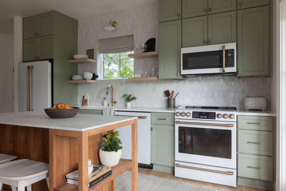 Transitional galley light wood floor and beige floor kitchen photo in San Francisco with an undermount sink, shaker cabinets, green cabinets, white backsplash, white appliances, an island and white countertops