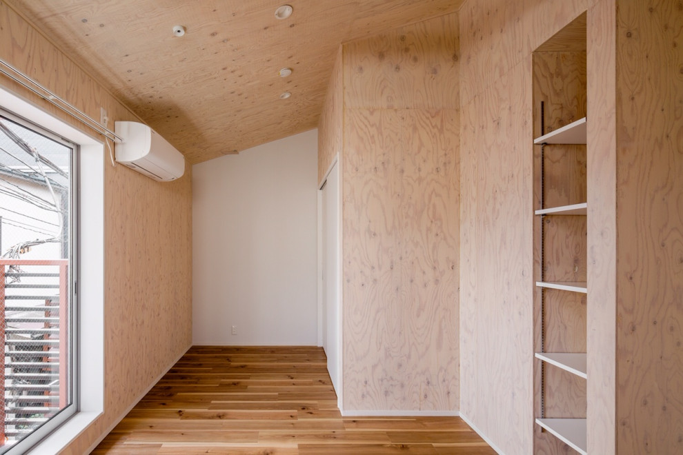 This is an example of a mid-sized scandinavian gender-neutral kids' room in Tokyo with beige walls, medium hardwood floors, beige floor, exposed beam and wood walls.