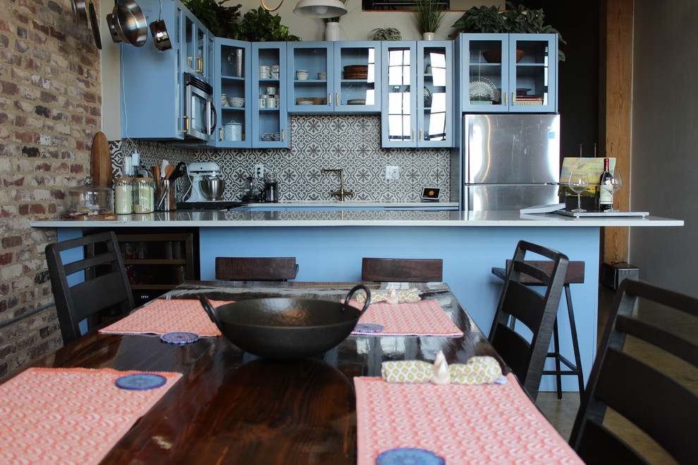 Inspiration for a mid-sized transitional u-shaped concrete floor and beige floor eat-in kitchen remodel in Atlanta with an undermount sink, glass-front cabinets, blue cabinets, quartzite countertops, multicolored backsplash, ceramic backsplash, stainless steel appliances, a peninsula and white countertops