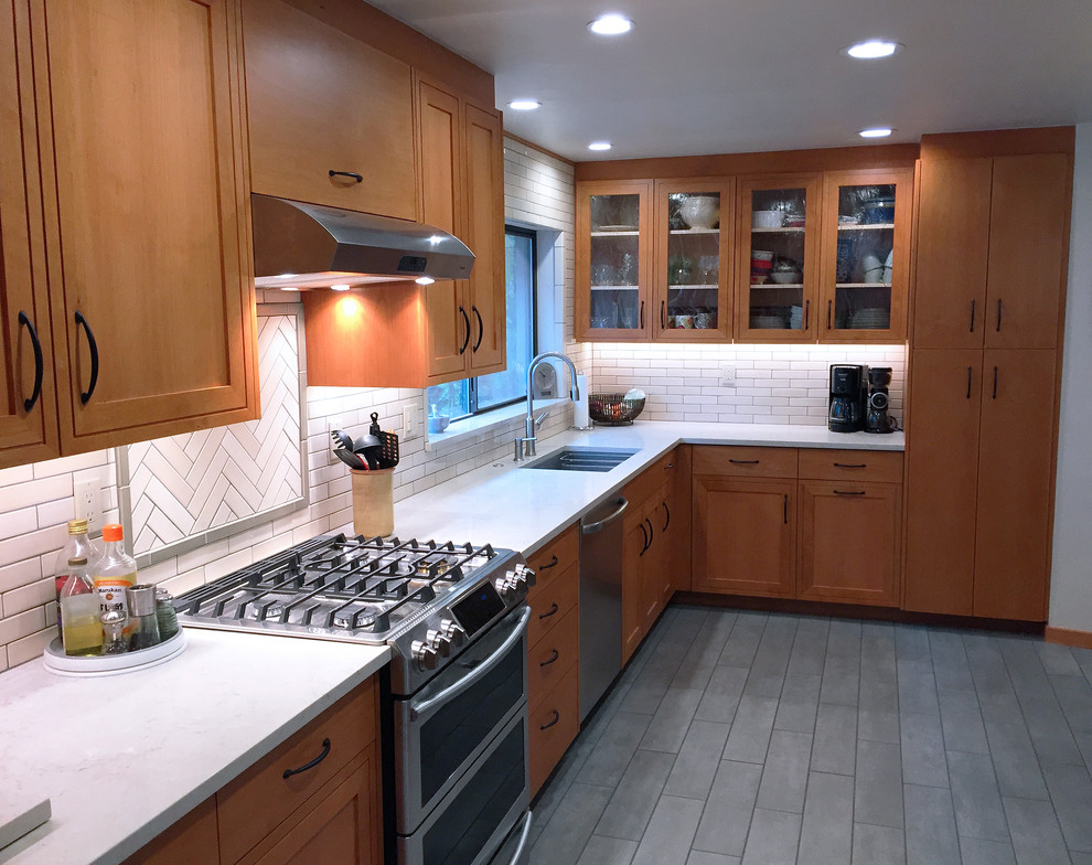 Inspiration for a mid-sized midcentury galley eat-in kitchen in Other with an integrated sink, flat-panel cabinets, medium wood cabinets, soapstone benchtops, white splashback, ceramic splashback, stainless steel appliances, ceramic floors, no island and grey floor.