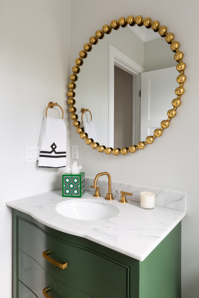Inspiration for a small transitional powder room in Boston with furniture-like cabinets, green cabinets, a two-piece toilet, grey walls, light hardwood floors, an undermount sink, marble benchtops, beige floor, white benchtops and a freestanding vanity.