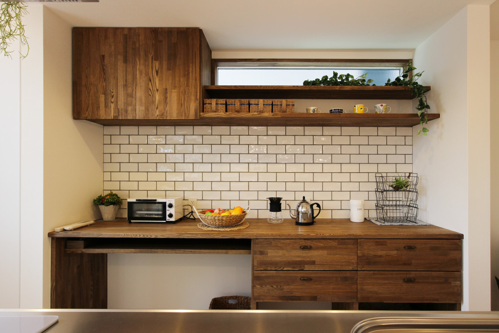 Modern inredning av ett mellanstort brun linjärt brunt kök med öppen planlösning, med en integrerad diskho, skåp i mörkt trä, träbänkskiva, vitt stänkskydd, stänkskydd i tunnelbanekakel, vita vitvaror, vinylgolv och grått golv