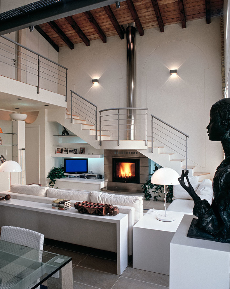 Expansive open concept living room in Milan with white walls, a ribbon fireplace and a metal fireplace surround.