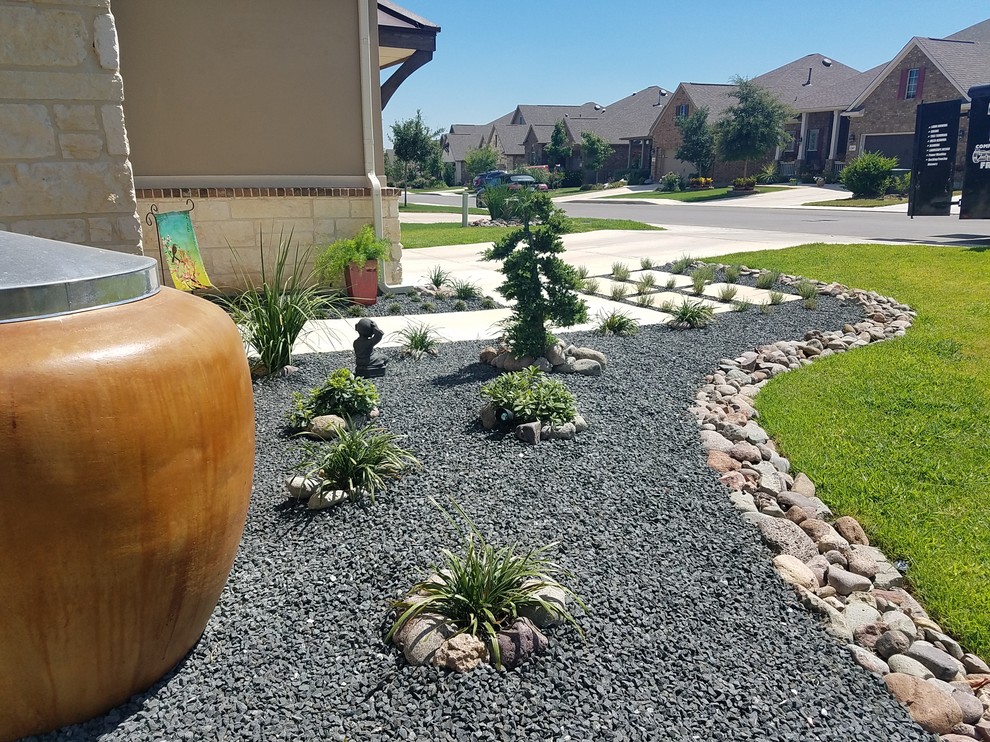Photo of a mid-sized asian front yard full sun xeriscape for summer in Other with a garden path and natural stone pavers.