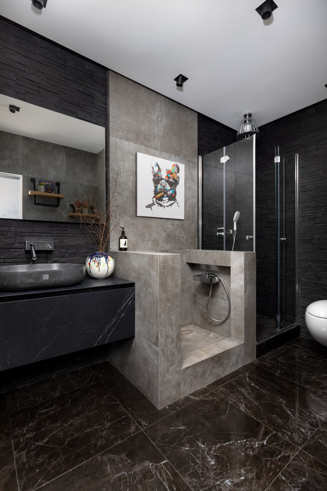 Idée de décoration pour une salle de bain design avec un placard à porte plane, des portes de placard noires, une douche d'angle, un carrelage noir, une vasque, un sol noir, une cabine de douche à porte battante, un plan de toilette noir et meuble-lavabo suspendu.