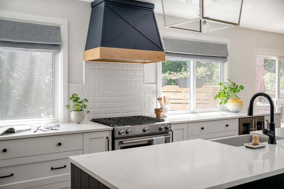 Large transitional l-shaped kitchen photo in Toronto with shaker cabinets and an island